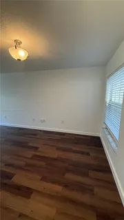 a view of room and hall with wooden floor