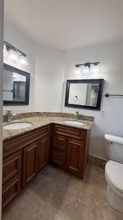 a spacious bathroom with a granite countertop toilet sink and a microwave