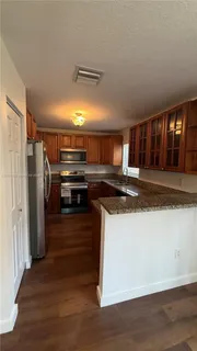 a kitchen with stainless steel appliances granite countertop a refrigerator and a stove