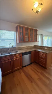 a kitchen with stainless steel appliances granite countertop a sink and a granite counter tops with wooden floors