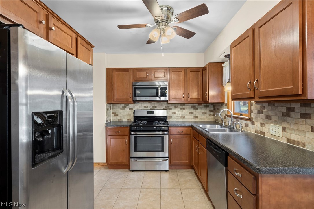 227 South Messner Road New Franklin, OH 44319 - Photo 20 of 44 Kitchen with stainless steel appliances, backsplash, sink, light tile floors, and ceiling fan