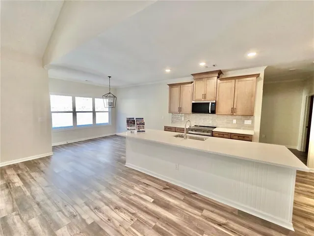 a view of kitchen with granite countertop cabinets and refrigerator