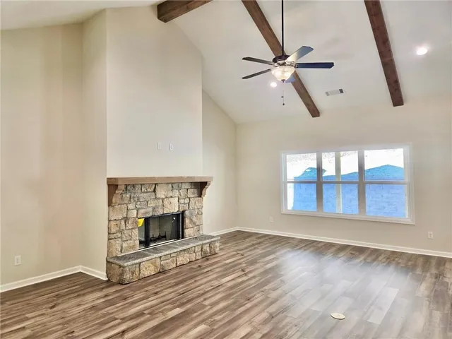 a view of an empty room with a window and fireplace