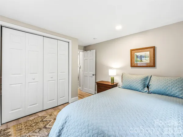 a bedroom with a bed and a painting on the wall