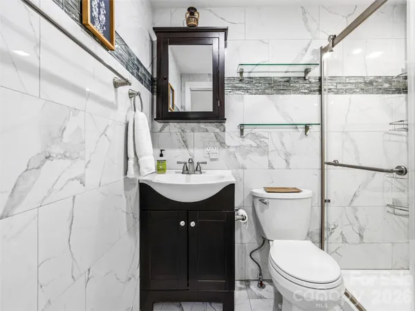 a bathroom with a toilet sink vanity and mirror