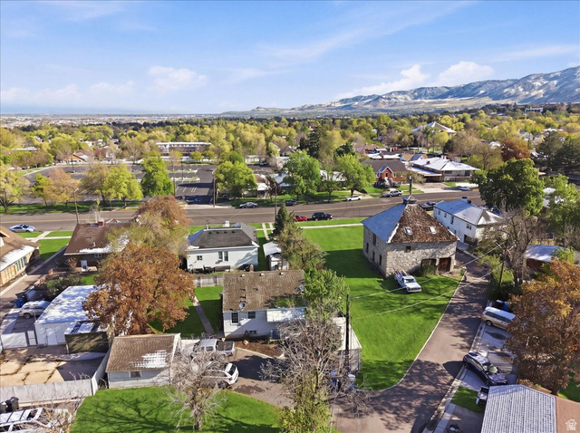348 East 200 North Logan, UT 84321 - Photo 11 of 41 Stone structure with a shingled roof, featuring a surrounding paved driveway and a manicured lawn