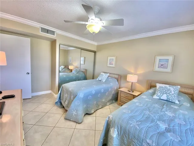 a bedroom with two beds and a ceiling fan