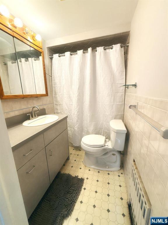 9-04 5th Street Fair Lawn, NJ 07410 - Photo 7 of 17 a bathroom with a sink a toilet and shower curtain