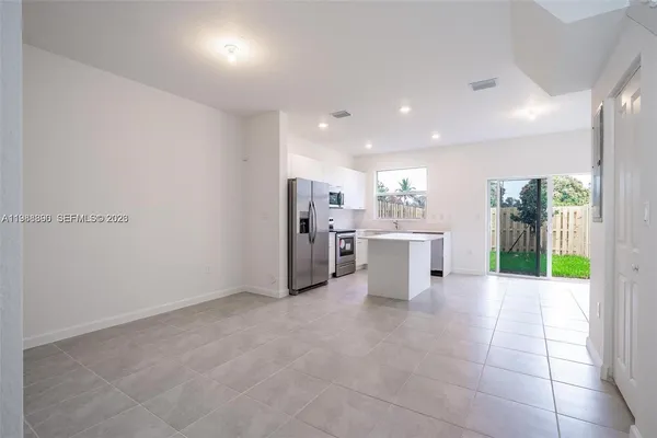 a kitchen with stainless steel appliances kitchen island sink refrigerator and cabinets