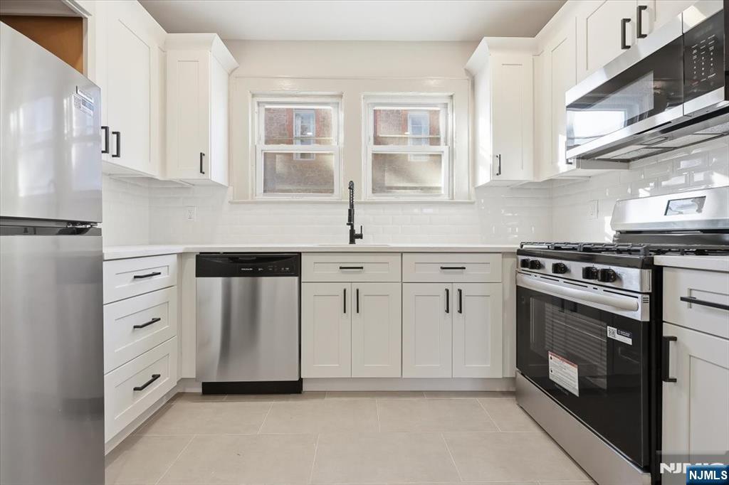 28 State Street, Unit 1 Bloomfield, NJ 07003 - Photo 4 of 8 a kitchen with white cabinets and white appliances
