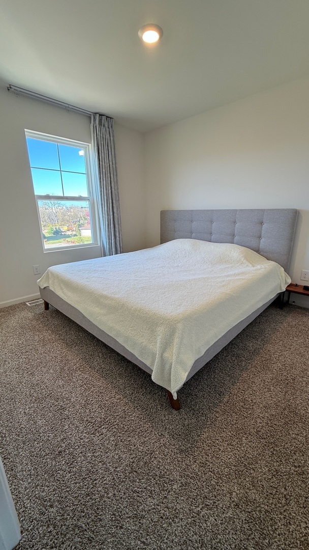 2008 Yellowstone Boulevard, Unit 2008 Mundelein, IL 60060 - Photo 15 of 25 a bed sitting in a room next to a window
