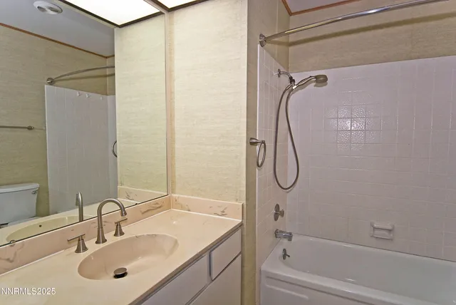a bathroom with a granite countertop sink vanity mirror and shower