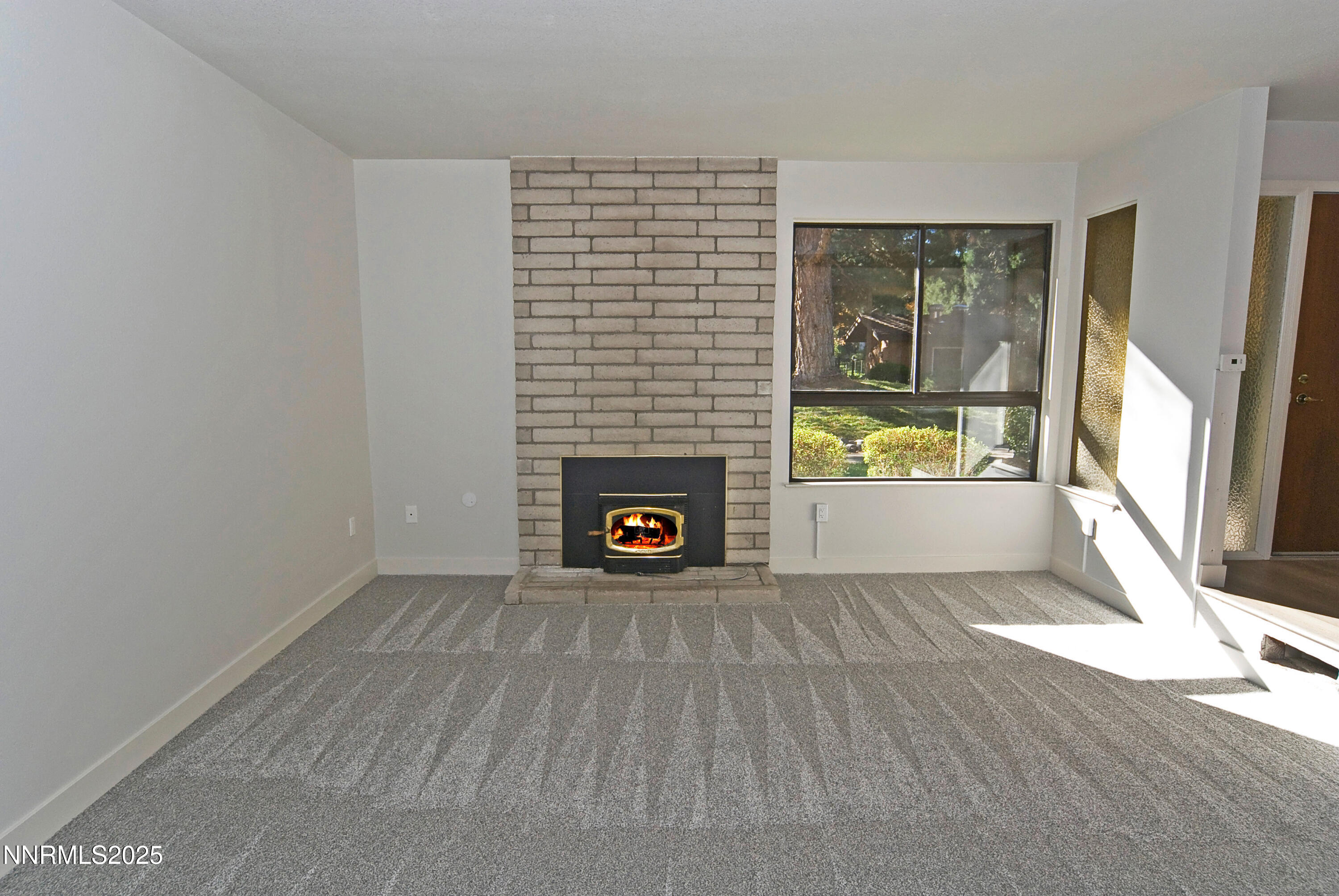 1433 Foster Drive Reno, NV 89509 - Photo 7 of 23 a view of an empty room with a fireplace and a window