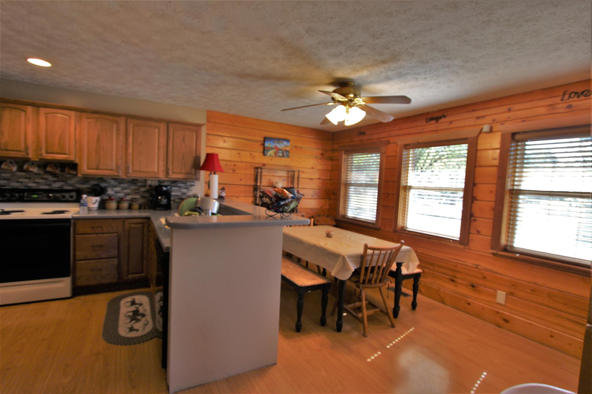 2296 Tracy Road Watertown, TN 37184 - Photo 21 of 29 a kitchen with stainless steel appliances granite countertop a stove top oven a sink a dining table and chairs with wooden floor