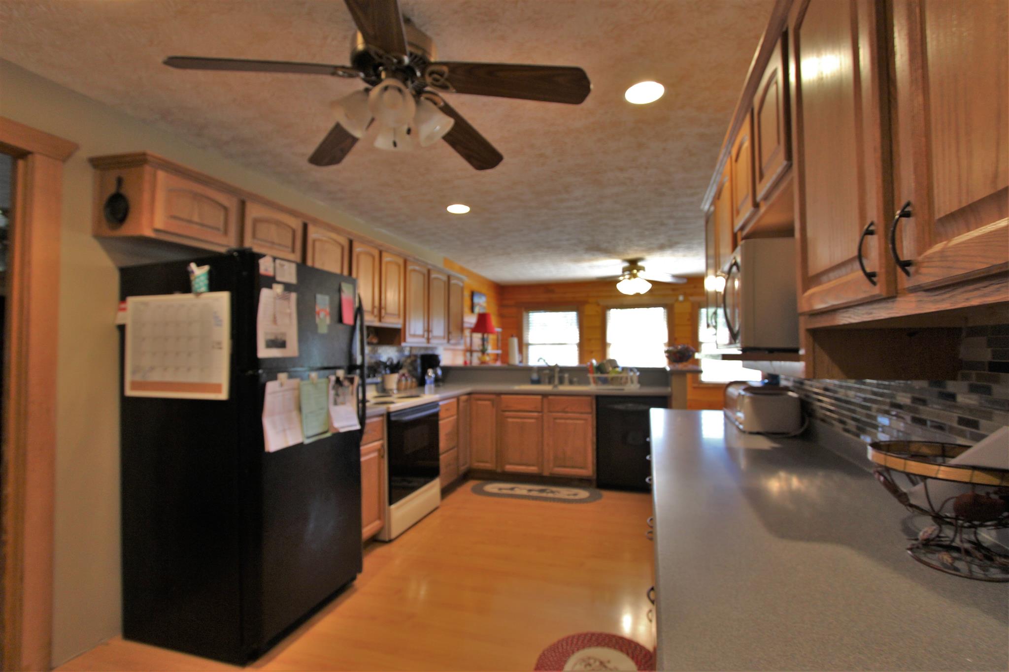 2296 Tracy Road Watertown, TN 37184 - Photo 24 of 29 a kitchen with stainless steel appliances kitchen island granite countertop a refrigerator a sink dishwasher a stove and a dining table with wooden floor