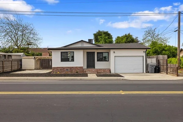 a front view of a house with a garden and garage