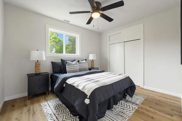 a bedroom with bed and wooden floor