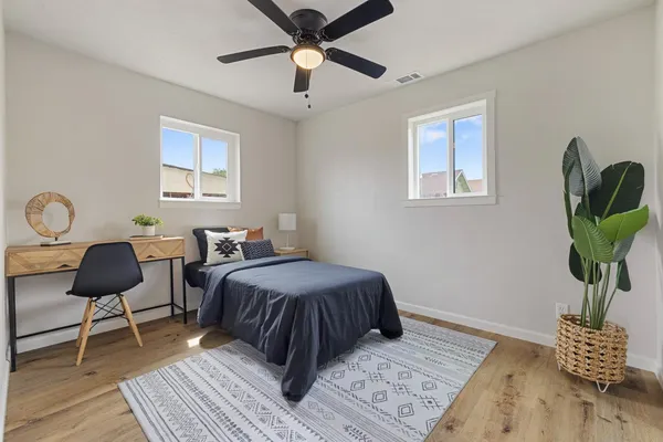 a bedroom with a bed wooden floor and a window