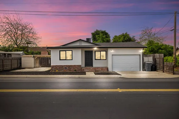 a front view of a house with a garden and yard
