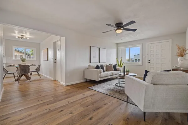 a living room with furniture and a wooden floor