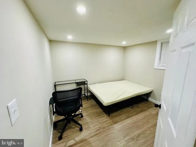 a kitchen with granite countertop a refrigerator a sink and white cabinets