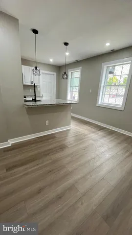 a large kitchen with stainless steel appliances granite countertop a sink a counter space and cabinets