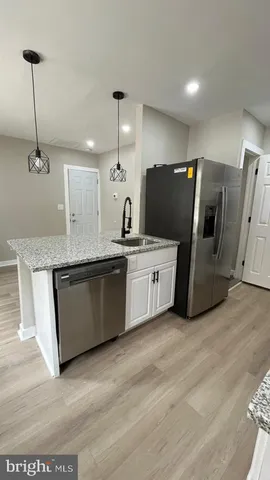 a kitchen with stainless steel appliances granite countertop a sink a refrigerator and a granite counter tops