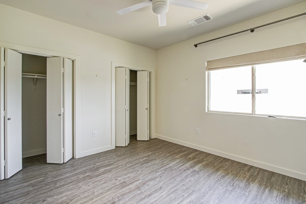 7805 Cooper Lane, Unit 602 Austin, TX 78745 - Photo 13 of 30 a view of an empty room with wooden floor and a window