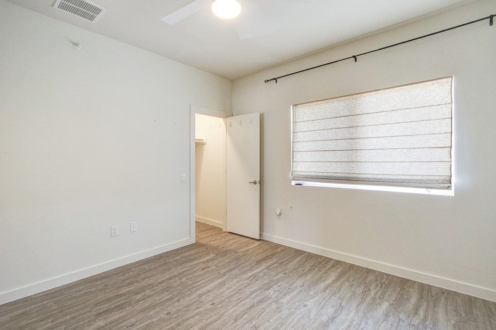 7805 Cooper Lane, Unit 602 Austin, TX 78745 - Photo 17 of 30 a view of an empty room with wooden floor and a window
