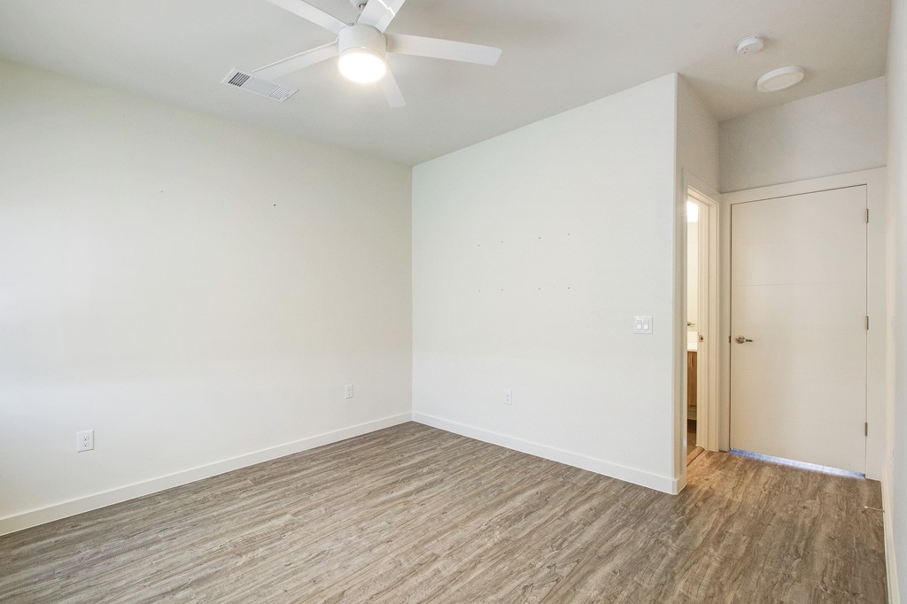 7805 Cooper Lane, Unit 602 Austin, TX 78745 - Photo 18 of 30 an empty room with wooden floor and fan