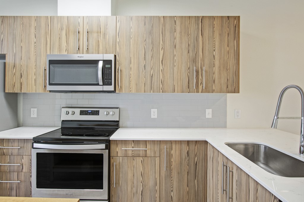 7805 Cooper Lane, Unit 602 Austin, TX 78745 - Photo 3 of 30 a kitchen with granite countertop cabinets stainless steel appliances and wooden cabinets