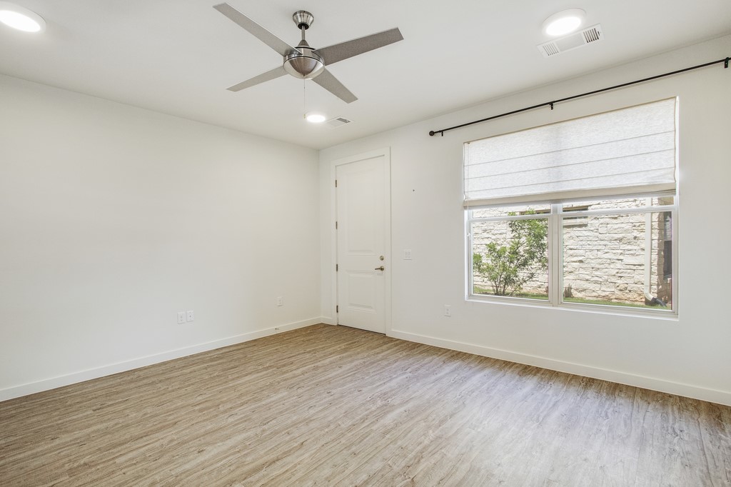 7805 Cooper Lane, Unit 602 Austin, TX 78745 - Photo 6 of 30 a view of an empty room with wooden floor and a window