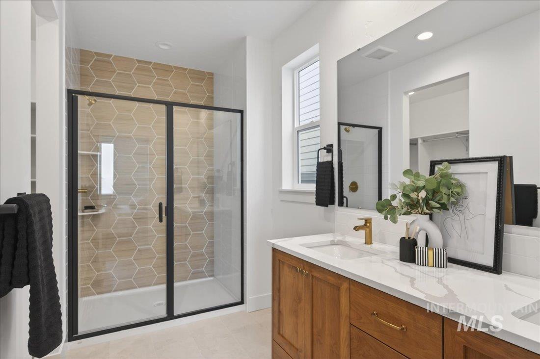 1268 West Swift Fox Street Meridian, ID 83642 - Photo 14 of 34 Bathroom featuring a stall shower, double vanity, and a spacious closet