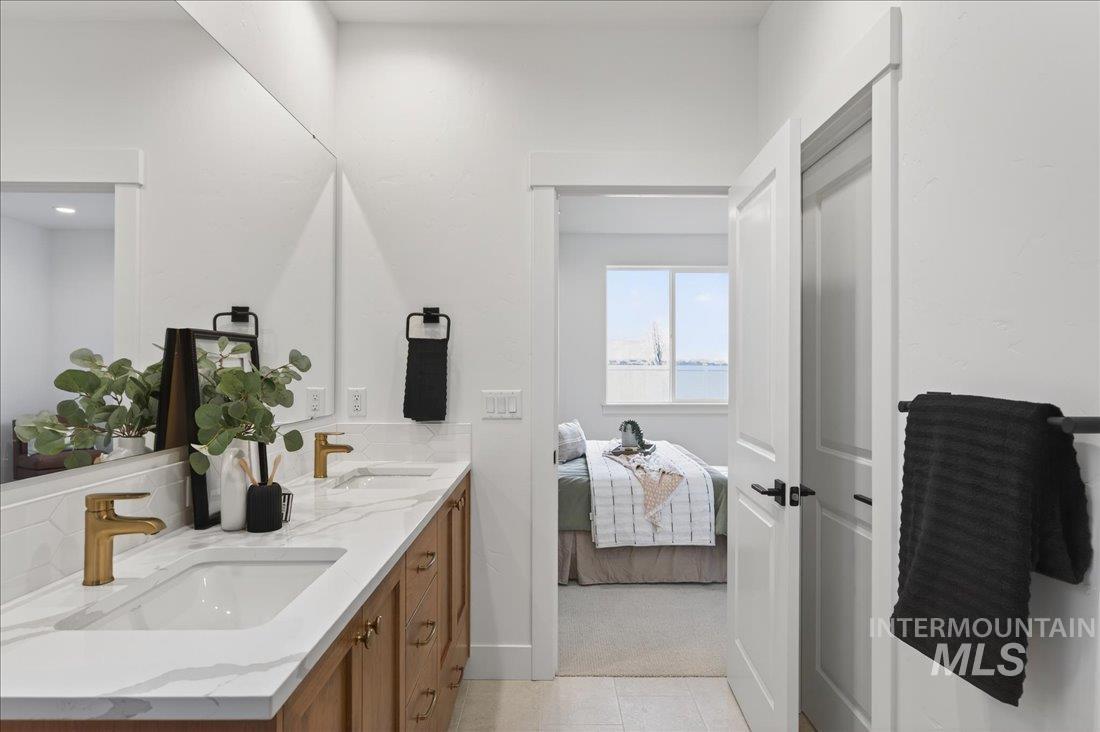 1268 West Swift Fox Street Meridian, ID 83642 - Photo 15 of 34 Full bathroom with double vanity, decorative backsplash, and ensuite bath