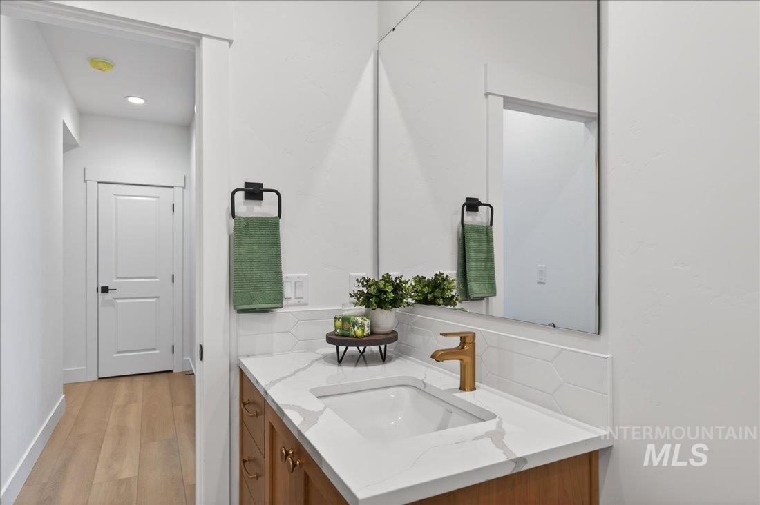 1268 West Swift Fox Street Meridian, ID 83642 - Photo 22 of 34 Bathroom featuring vanity, light wood-style flooring, decorative backsplash, and recessed lighting