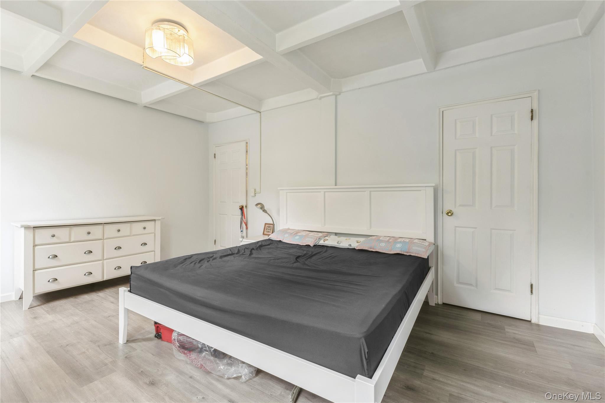 147-57 Charter Road, Unit 26D Queens, NY 11435 - Photo 11 of 21 Bedroom featuring beam ceiling, coffered ceiling, and light wood-style flooring