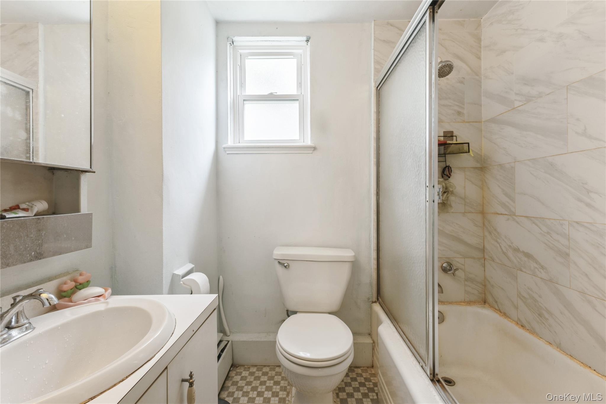 147-57 Charter Road, Unit 26D Queens, NY 11435 - Photo 17 of 21 Full bath with combined bath / shower with glass door, vanity, and baseboard heating