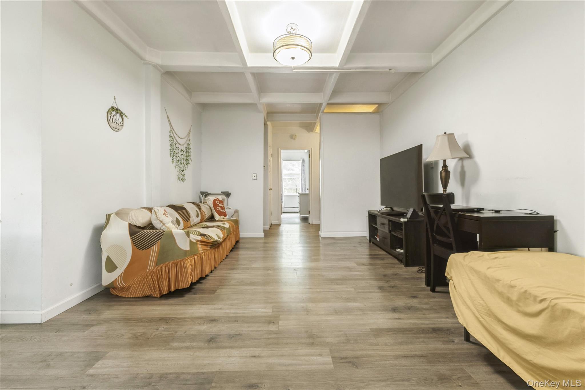 147-57 Charter Road, Unit 26D Queens, NY 11435 - Photo 3 of 21 Living area with beamed ceiling, coffered ceiling, and wood finished floors