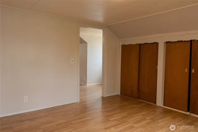 an empty room with wooden floor and closet