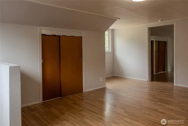 a view of empty room with wooden floor