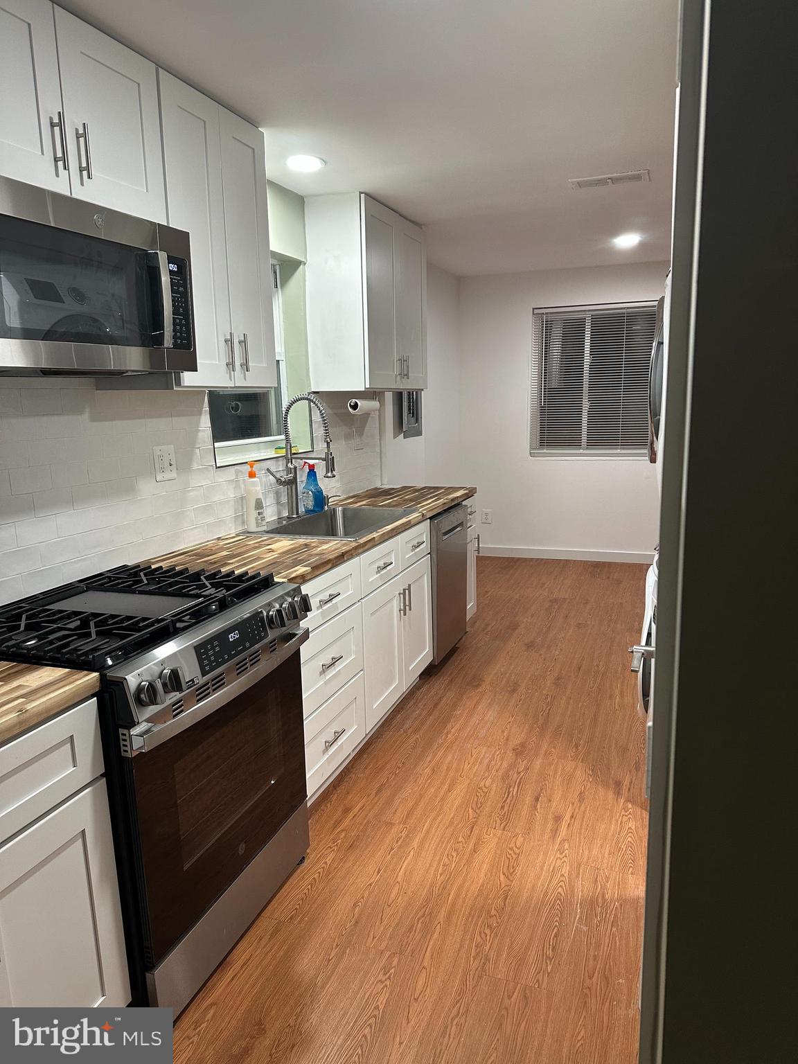 8411 11th Avenue Silver Spring, MD 20903 - Photo 19 of 24 a kitchen with stainless steel appliances granite countertop a stove a sink and a microwave