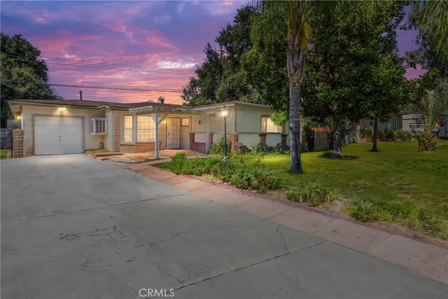 a front view of a house with a yard and trees