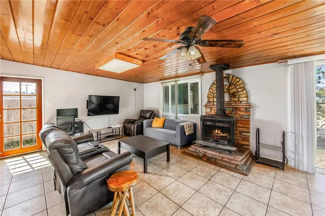 a living room with furniture a flat screen tv and kitchen view