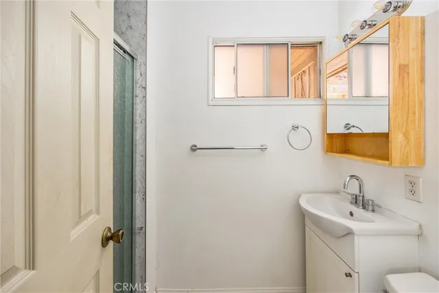 a bathroom with a sink and mirror with window