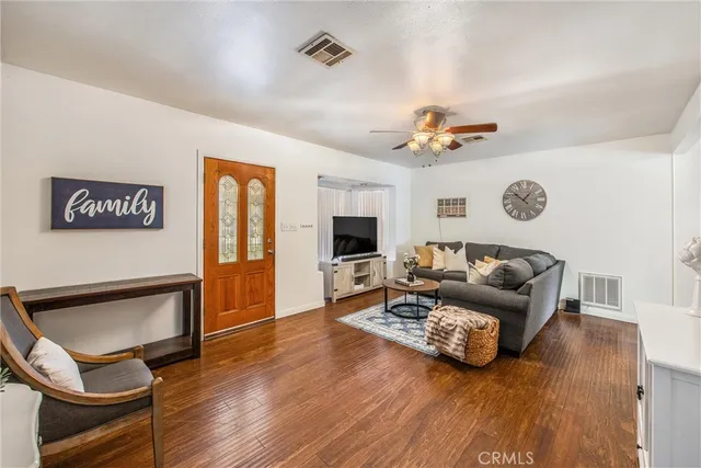 a living room with furniture a ceiling fan and a rug