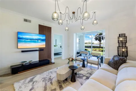 a living room with furniture a chandelier and a flat screen tv