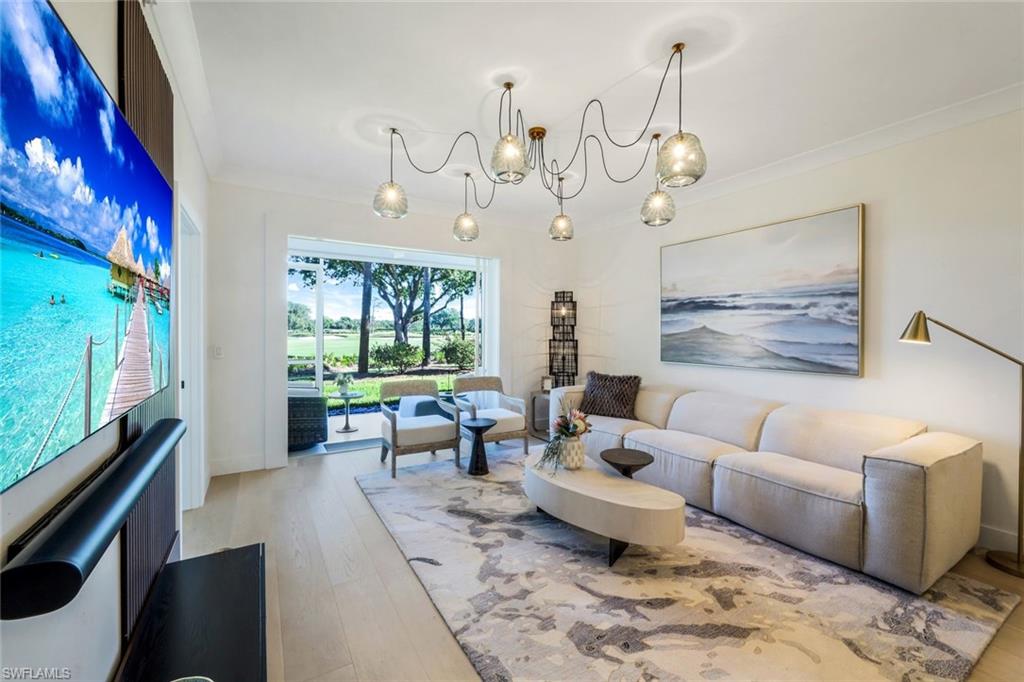 26871 Clarkston Drive, Unit 102 Bonita Springs, FL 34135 - Photo 13 of 50 a living room with couch wooden floor and a large window