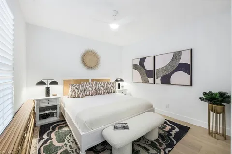 a bedroom with a bed and a potted plant on dresser