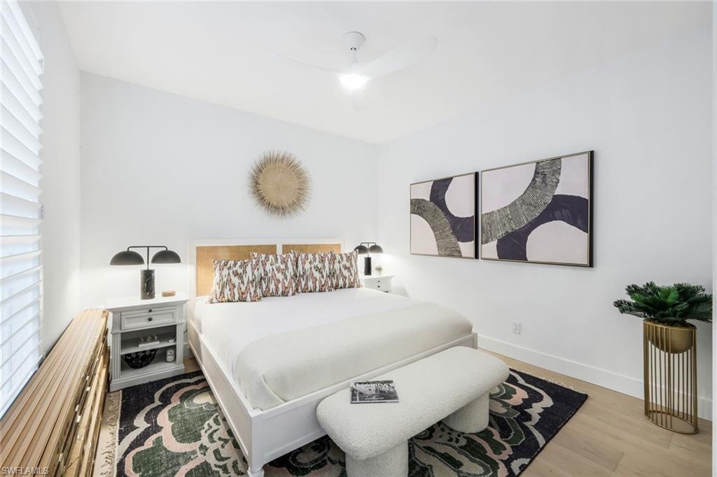 26871 Clarkston Drive, Unit 102 Bonita Springs, FL 34135 - Photo 15 of 50 a bedroom with a bed and a potted plant on dresser