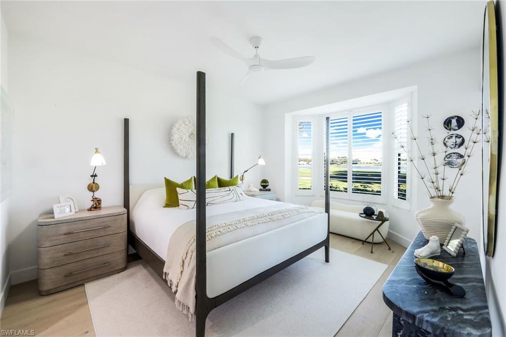 26871 Clarkston Drive, Unit 102 Bonita Springs, FL 34135 - Photo 18 of 50 a bedroom with a bed and wooden floor